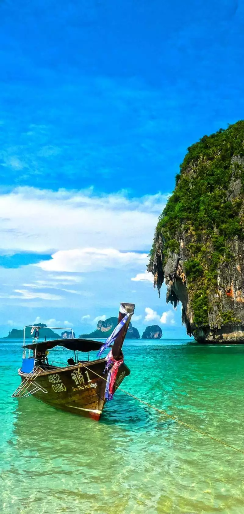 Παραδοσιακή βάρκα της Ταϊλάνδης που είναι αραγμένη στα κρυστάλλινα νερά του νησιού και εξυπηρετεί στη μεταφορά των ταξιδιωτών